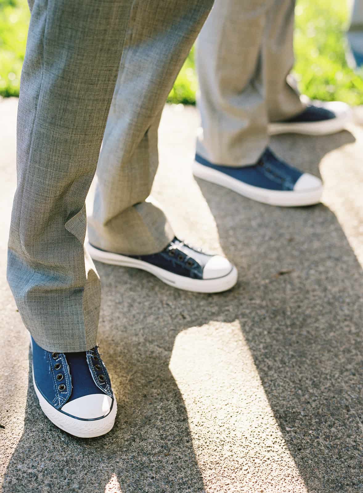 Closeup of groomsmen's blue converse shoes