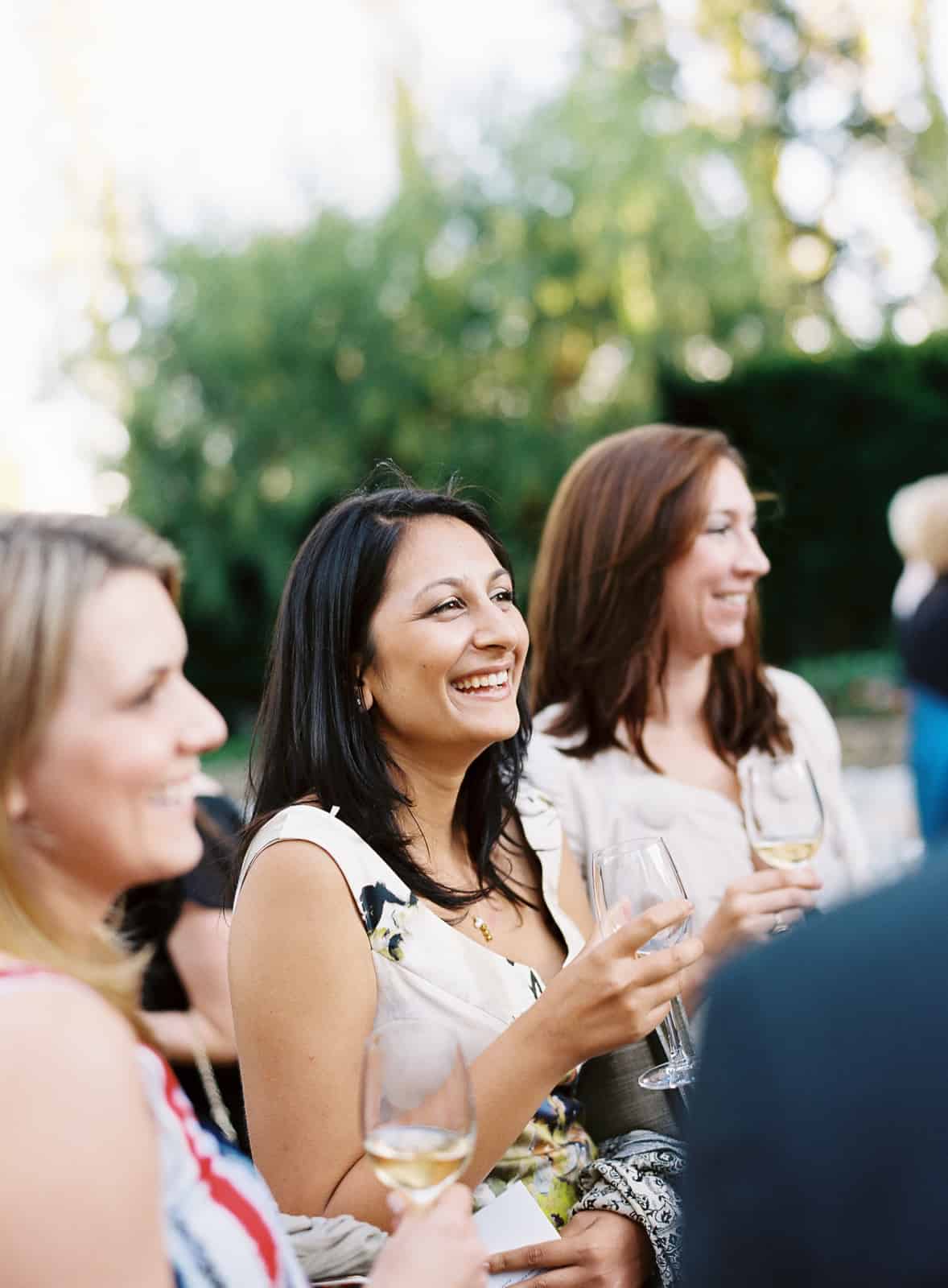 Smiling guests drinking white wine