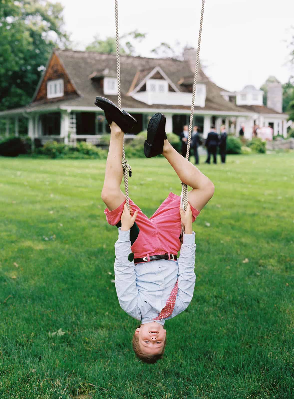 boy upside down on a swing