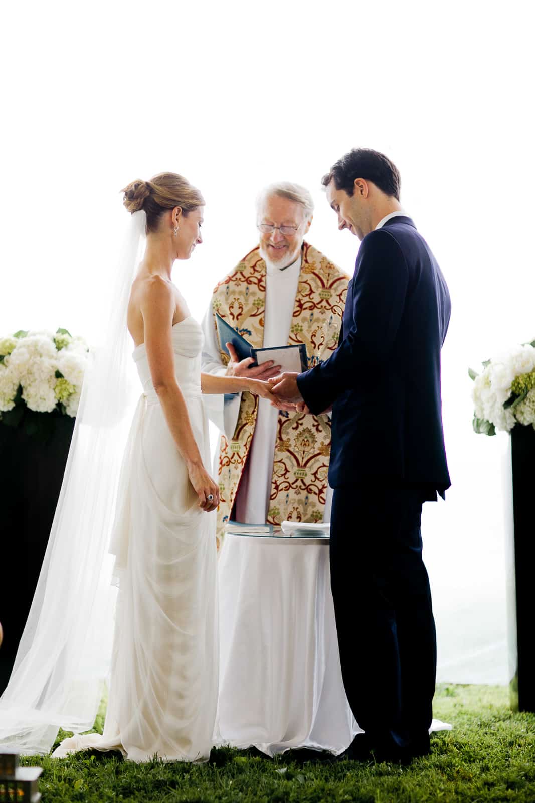groom placing ring on bride