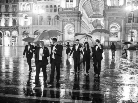 Guests at black tie gay destination wedding walking across Piazza del Duomo in Milan Italy