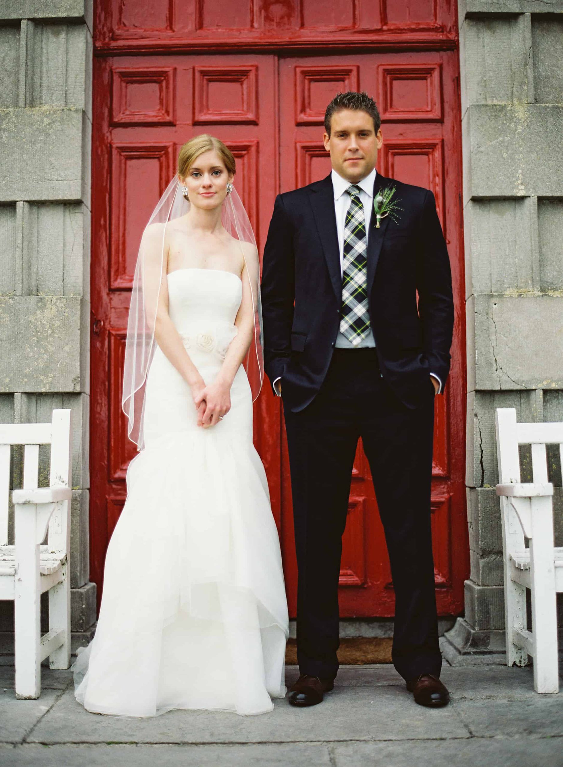 Bride and groom in front of a red door