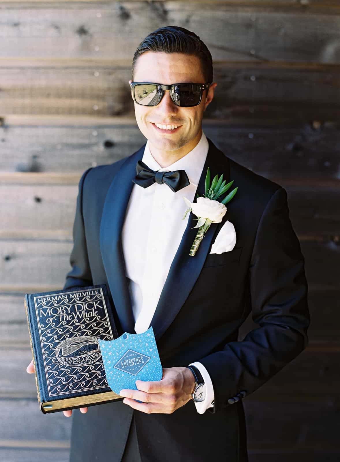 black tie groom with moby dick book gift from bride