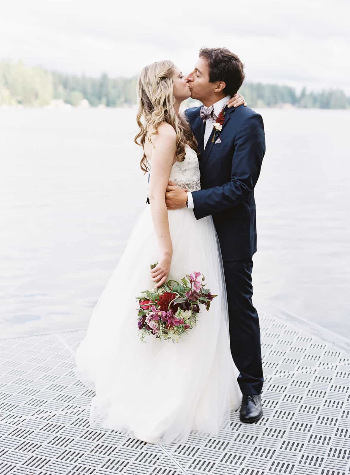married couple kissing on dock