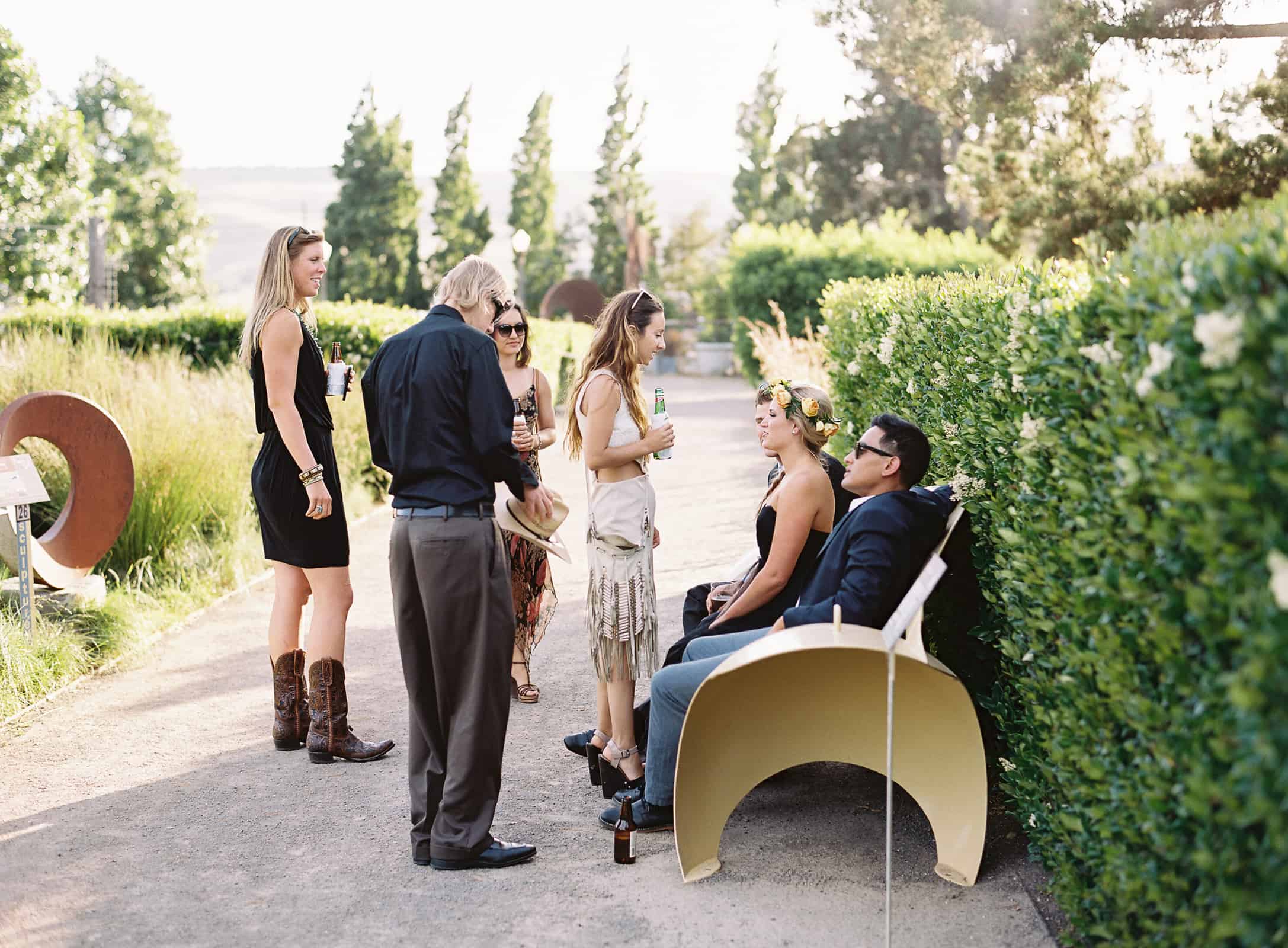 wedding guests mingling in art garden