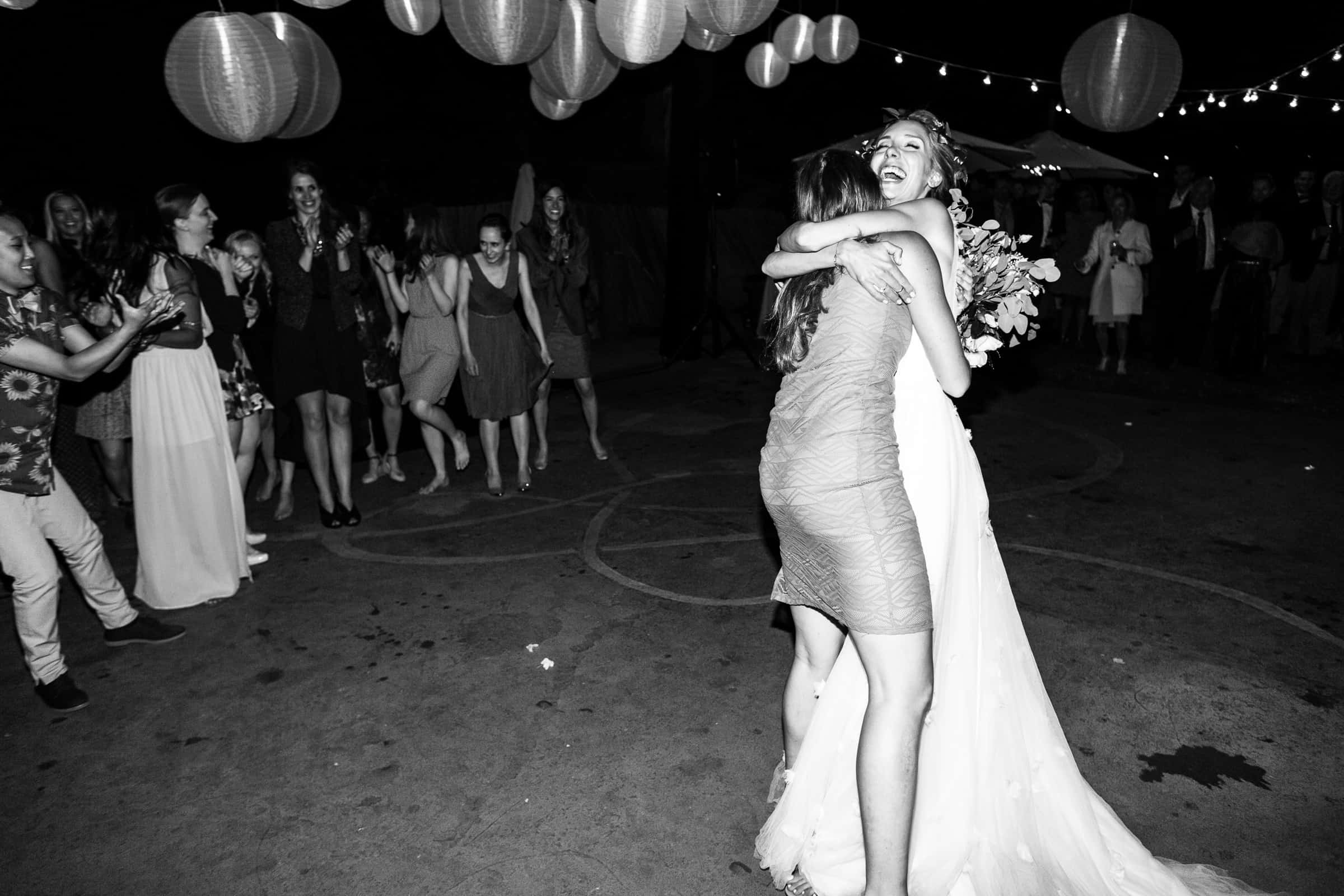 bride hugging girl who caught bouquet