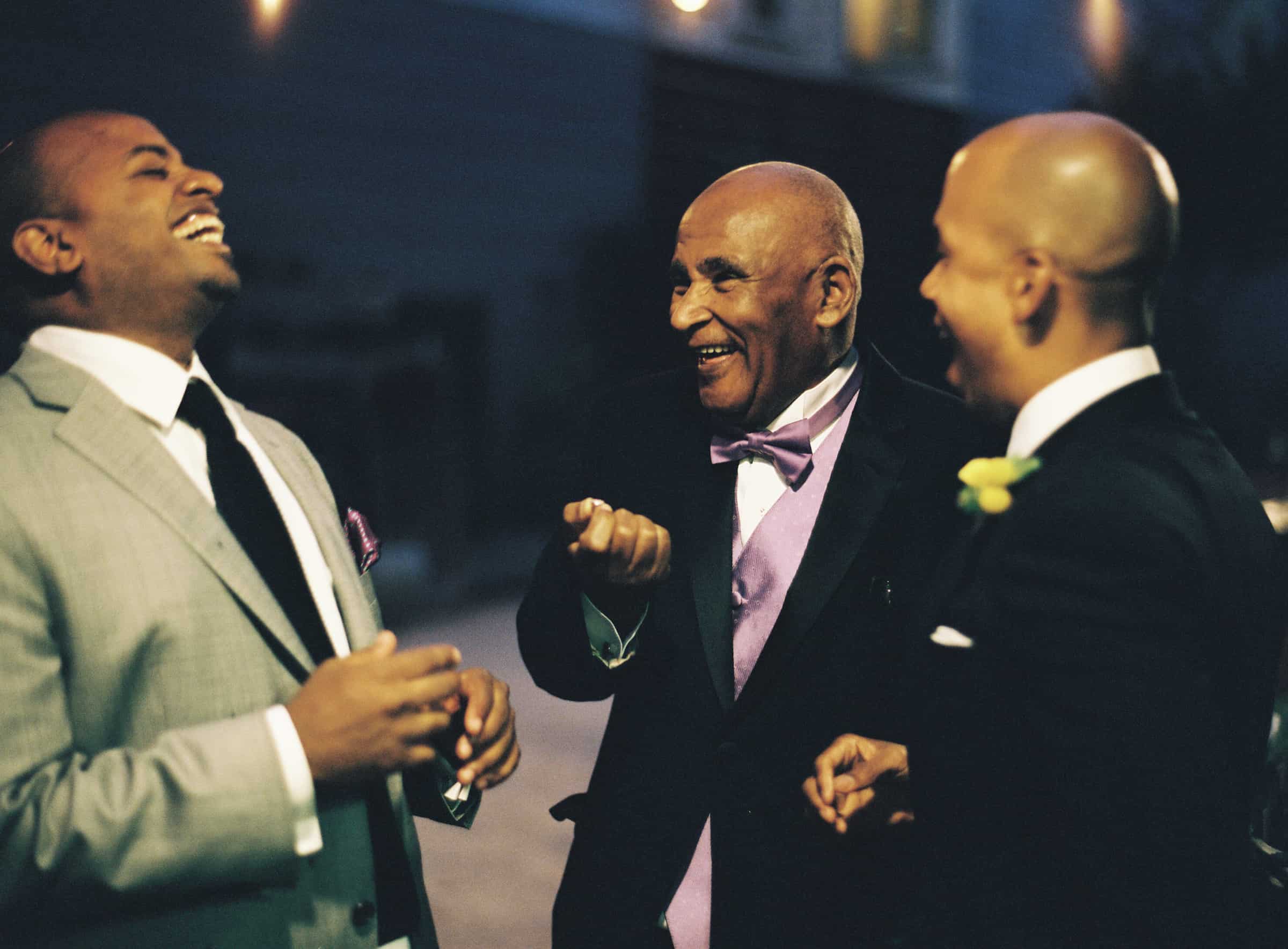 groom laughing with guests at night