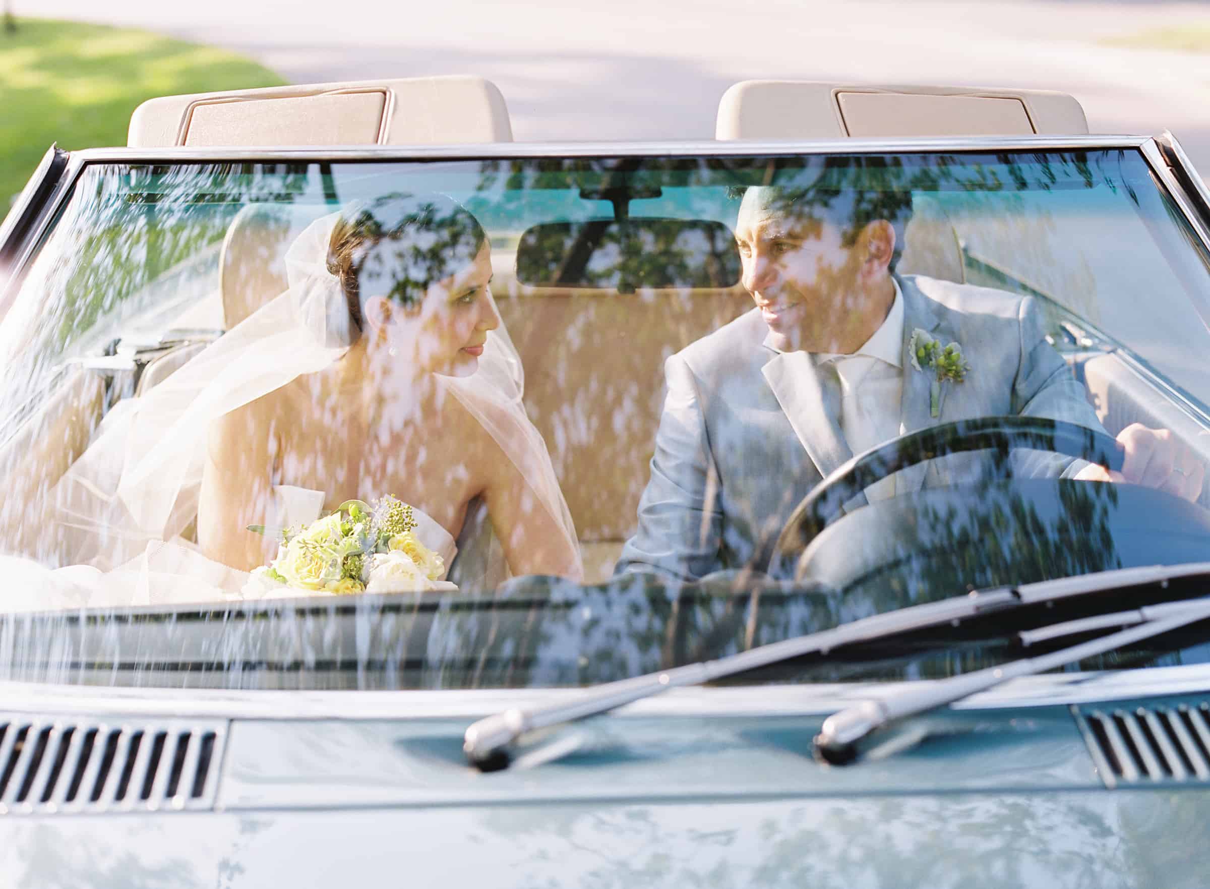 photo of married couple through vintage car window