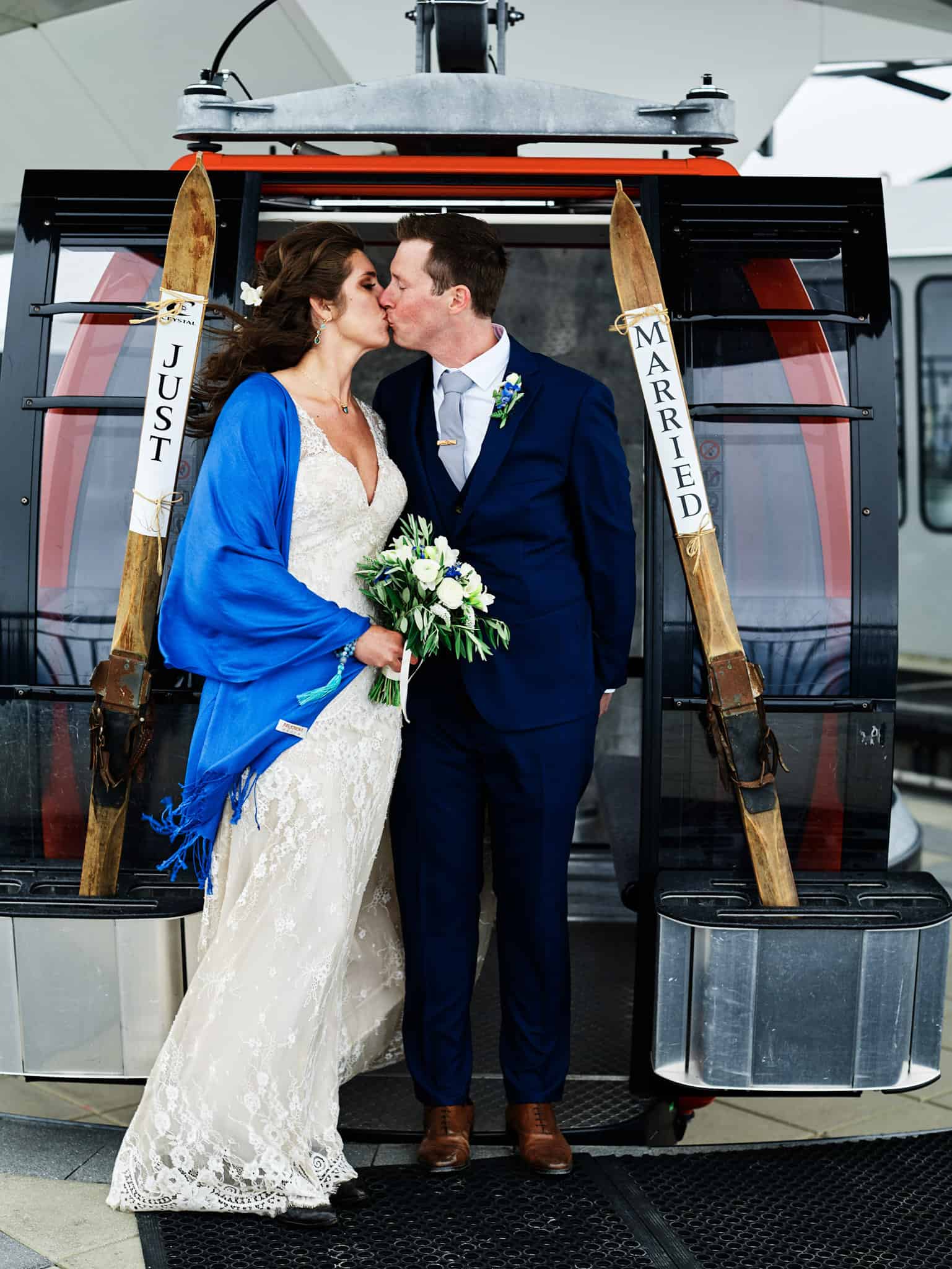 bride and groom kissing near ski lift after wedding at crystal mountain