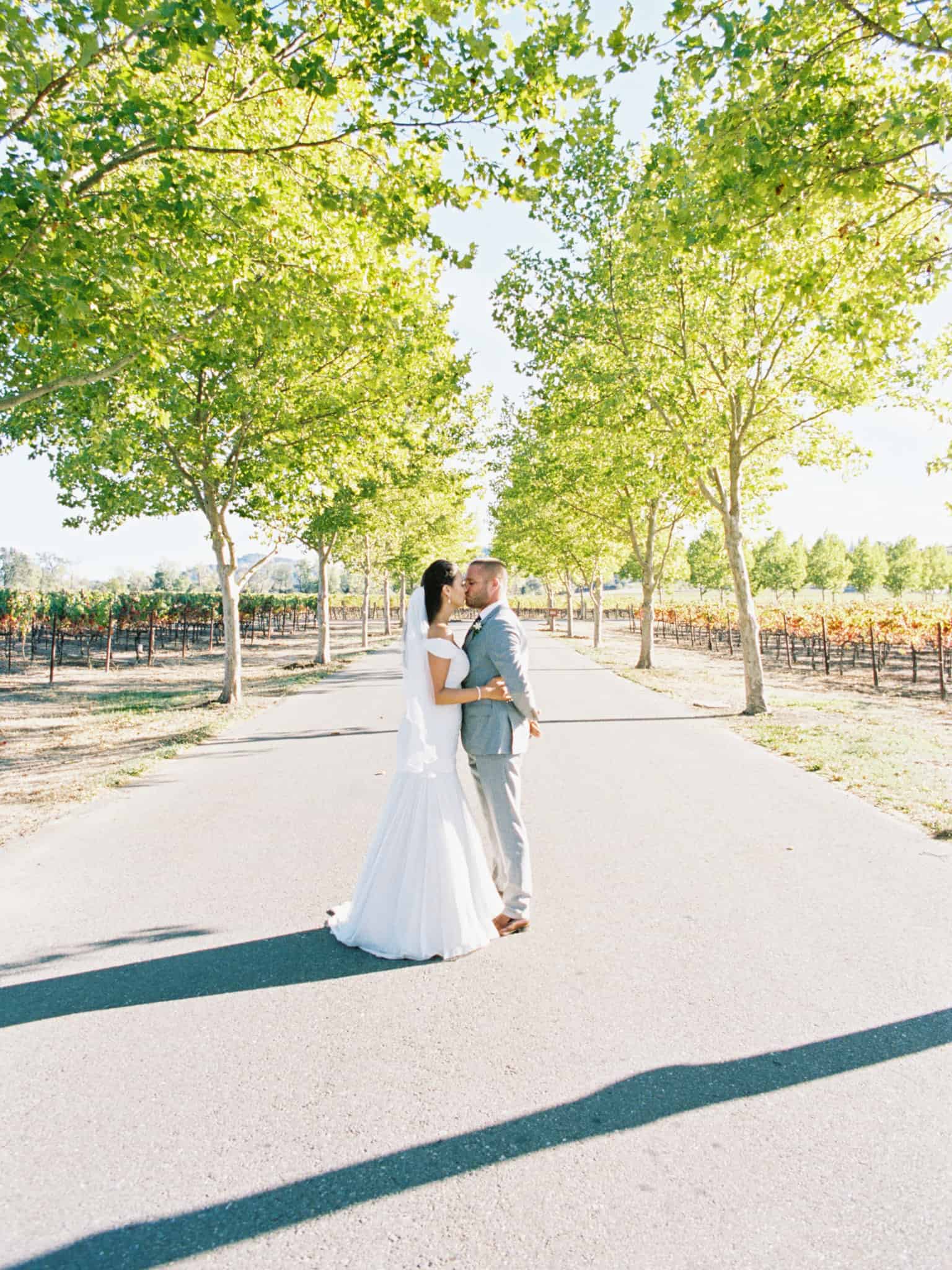 couple kissing on tree lined street in napa