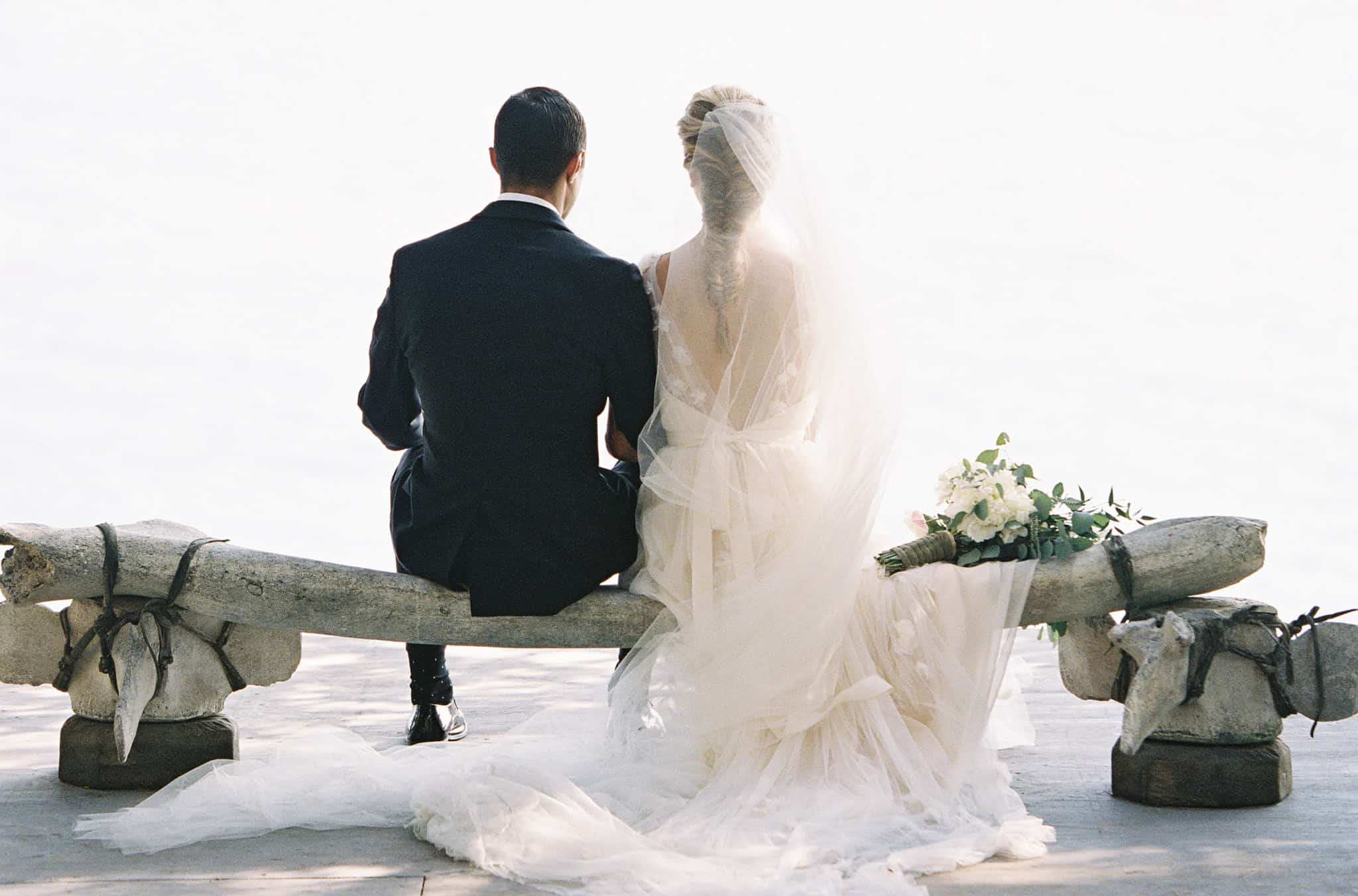 bride and groom sitting on whale bone bench