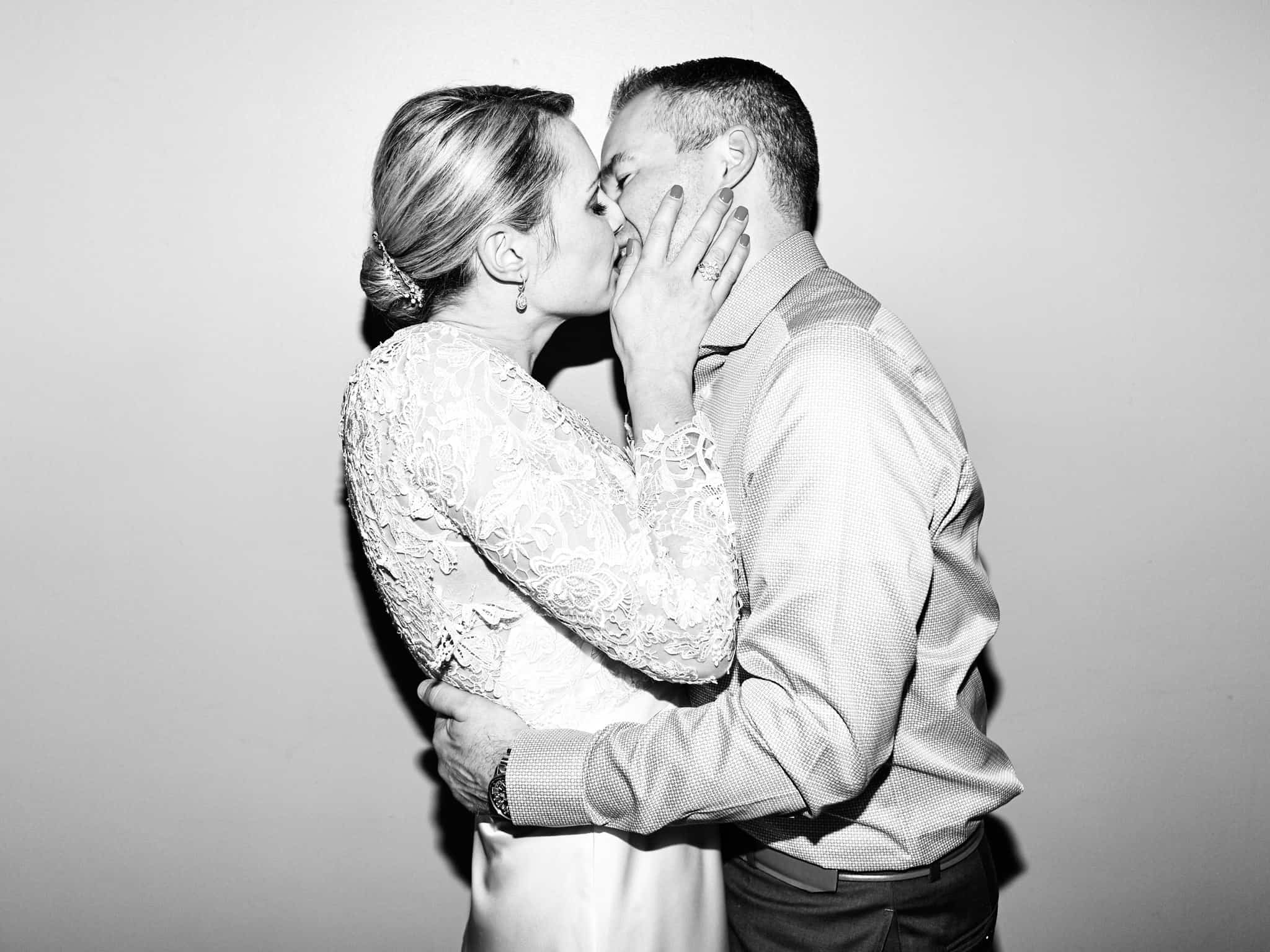bride and groom kissing in black and white