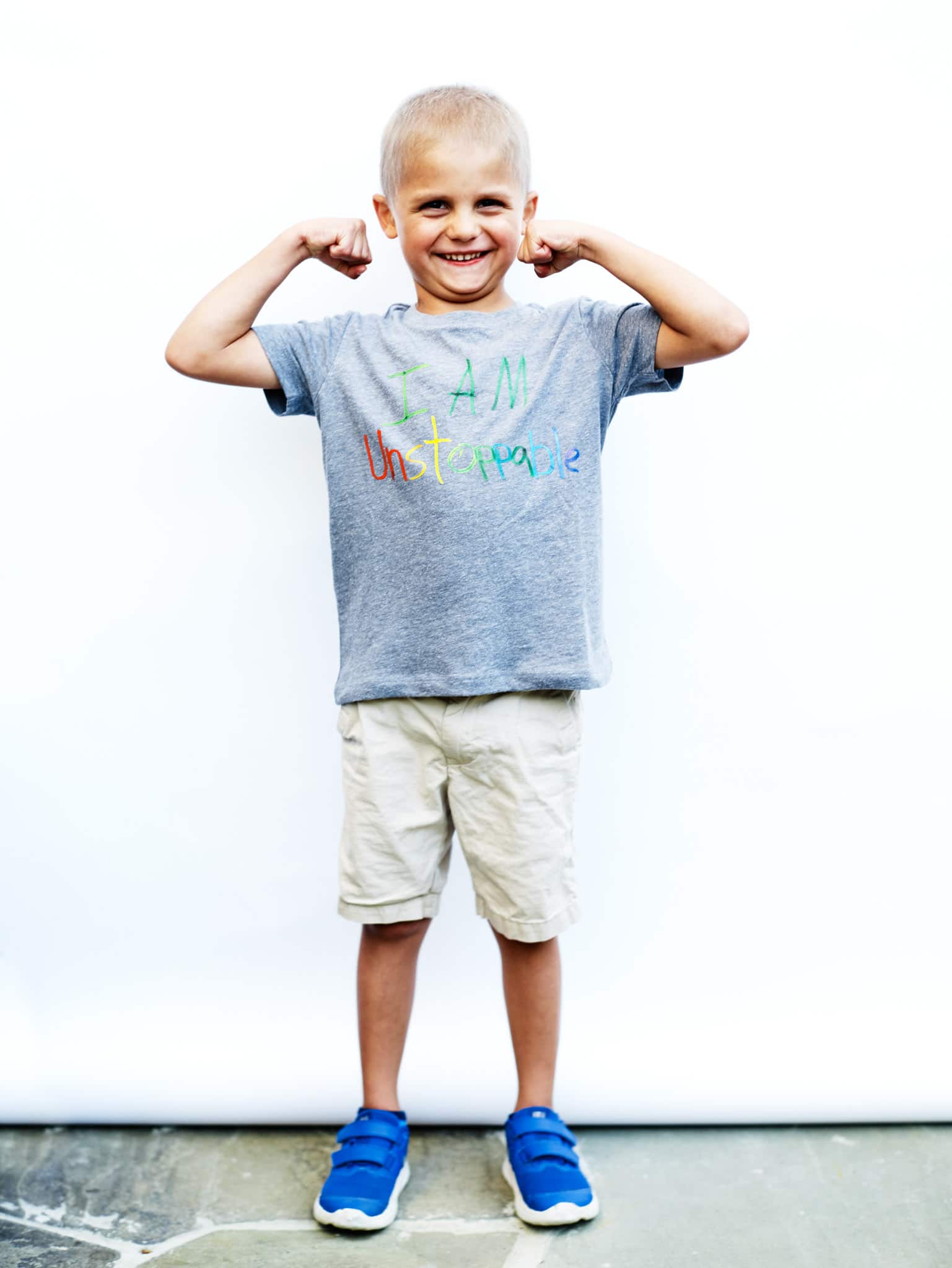 boy flexing muscles wearing inspirational shirt