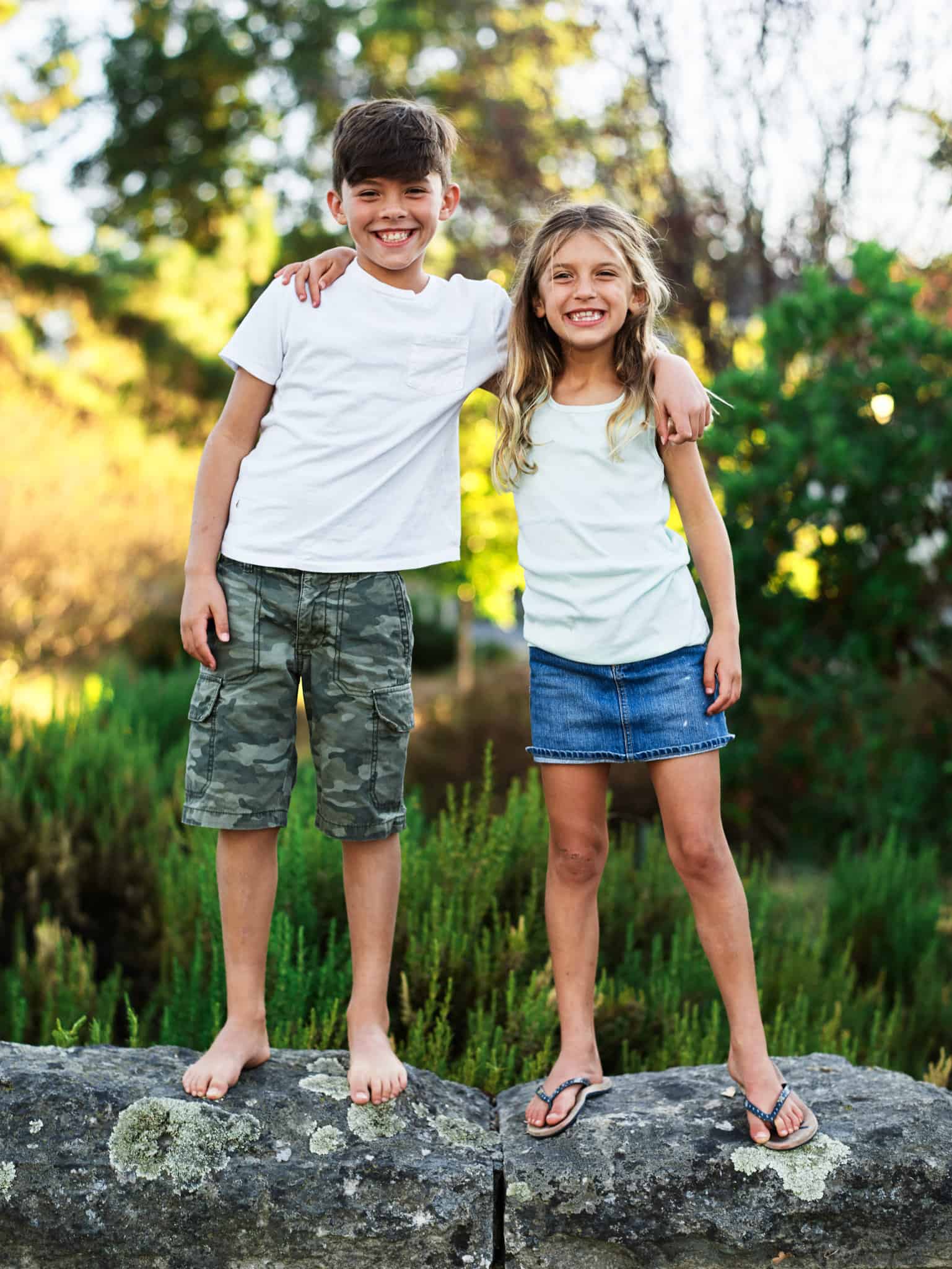 kid brother and sister standing on wall