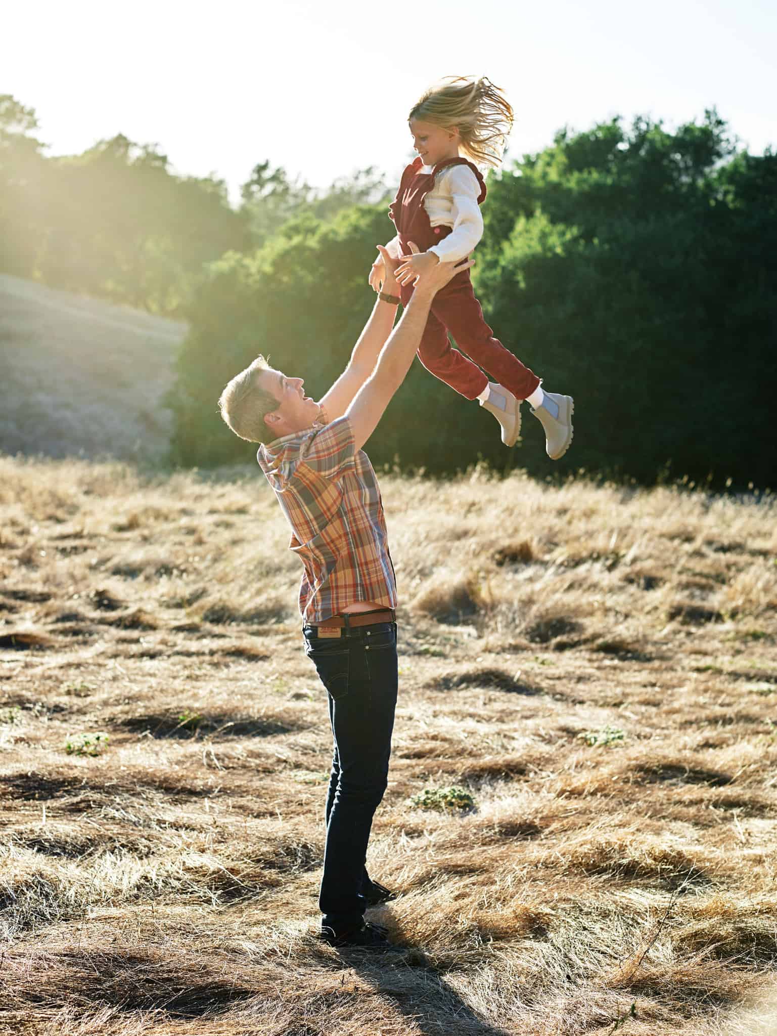 dad tossing daughter in the air during napa family session