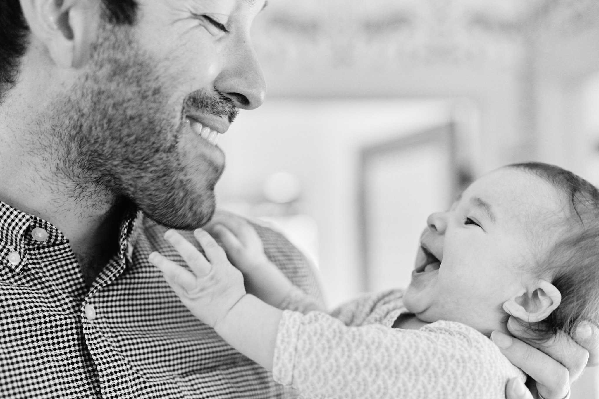 father holding laughing baby