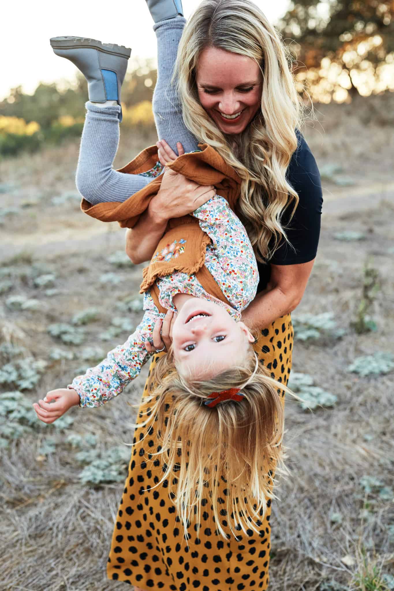 mom holding daughter upside down