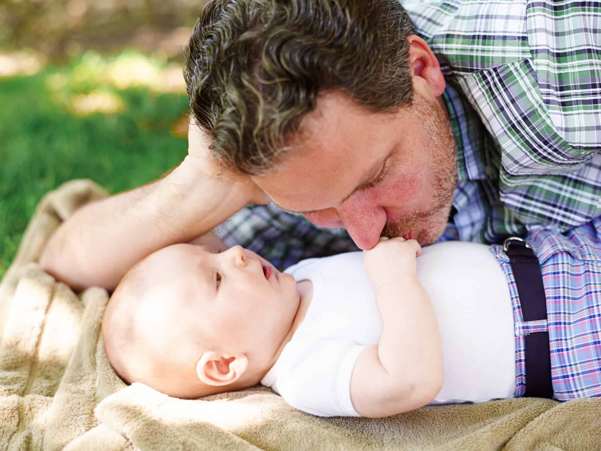 Father kissing baby on hand